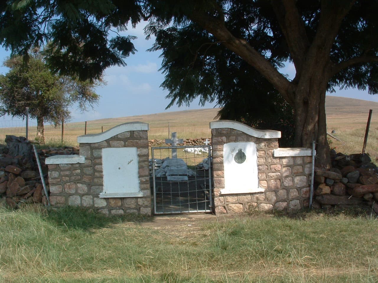 A stone gate with a tree in the background
AI-generated content may be incorrect.