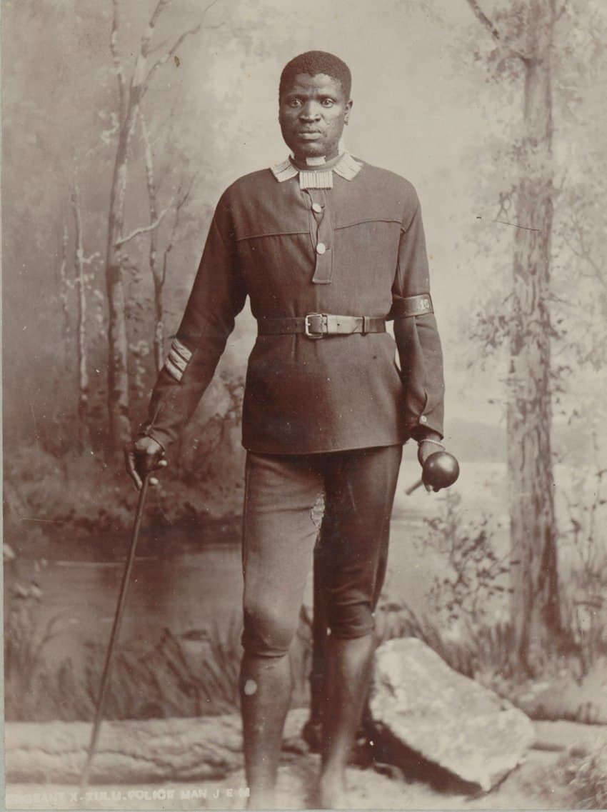A person in uniform with a cane AI-generated content may be incorrect.